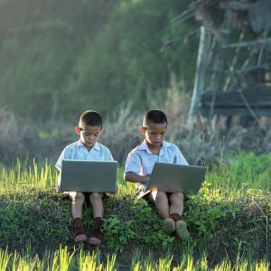 two children playing on gaming laptops